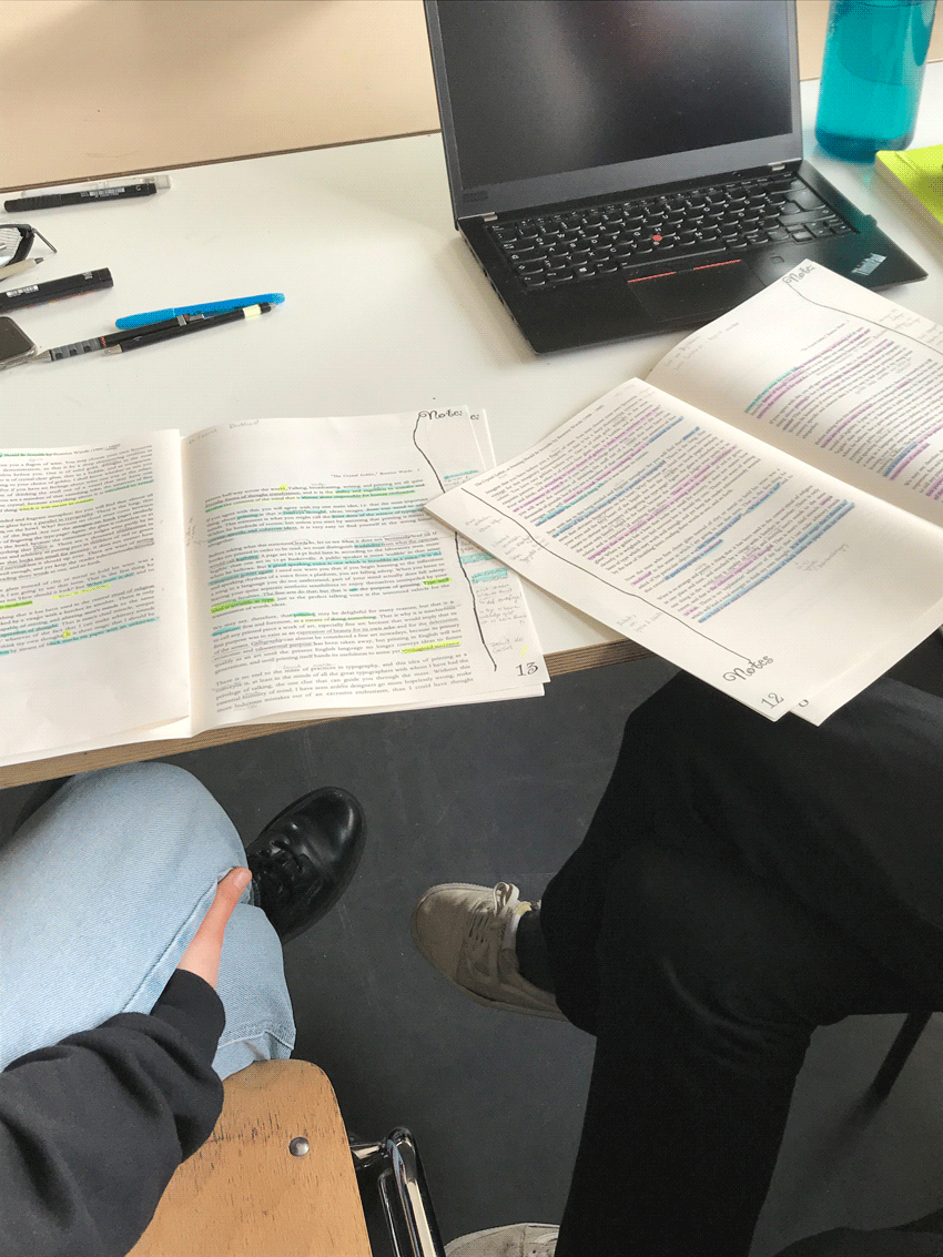 Zwei Texte mit farbigern Unterstreichungen die auf einem Schreibtisch liegen